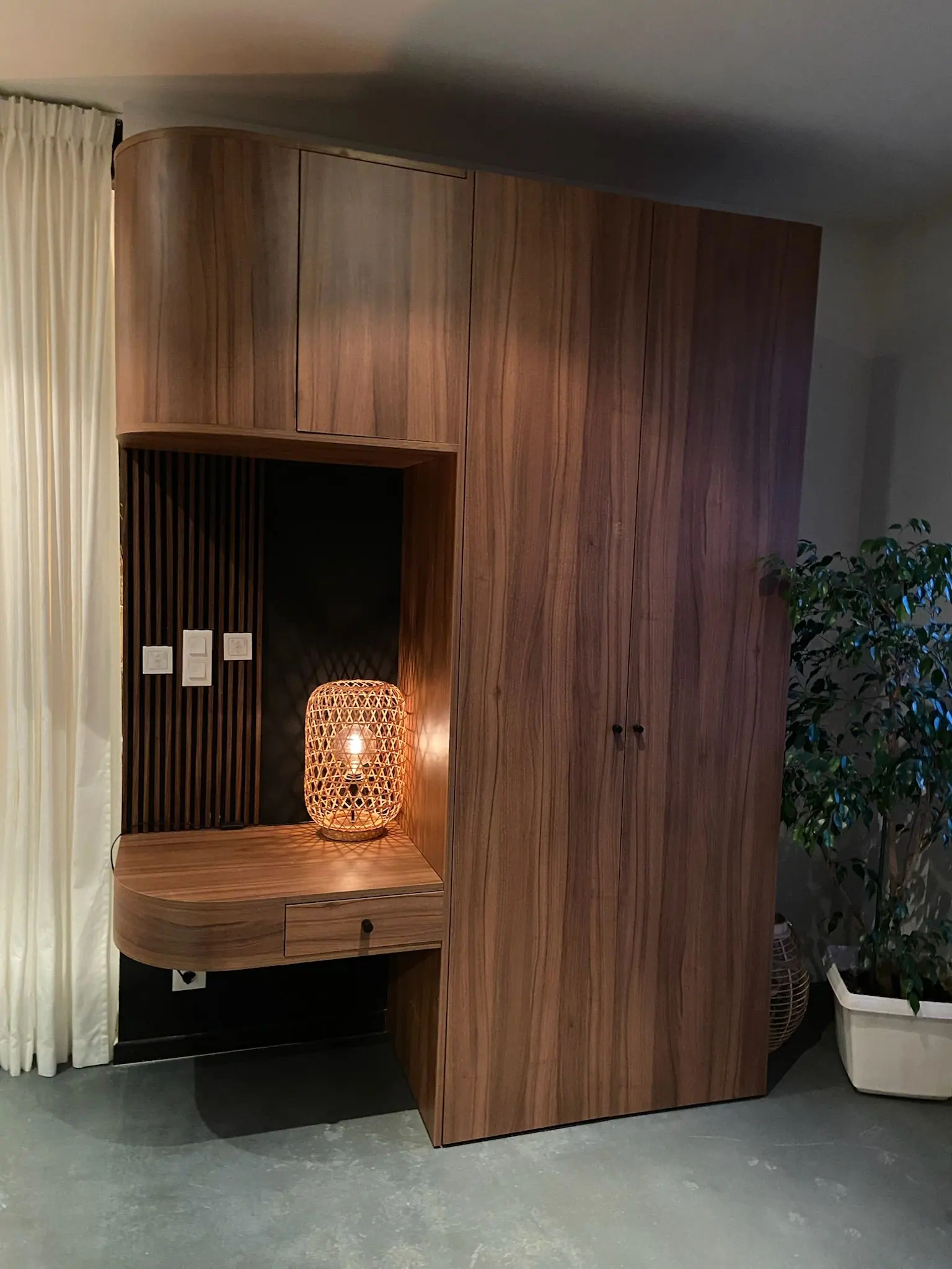 Meuble de rangement en bois foncé avec niche éclairée